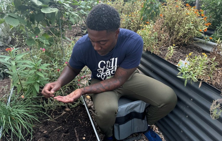 timothy sitting in the garden doing some work with seedlings