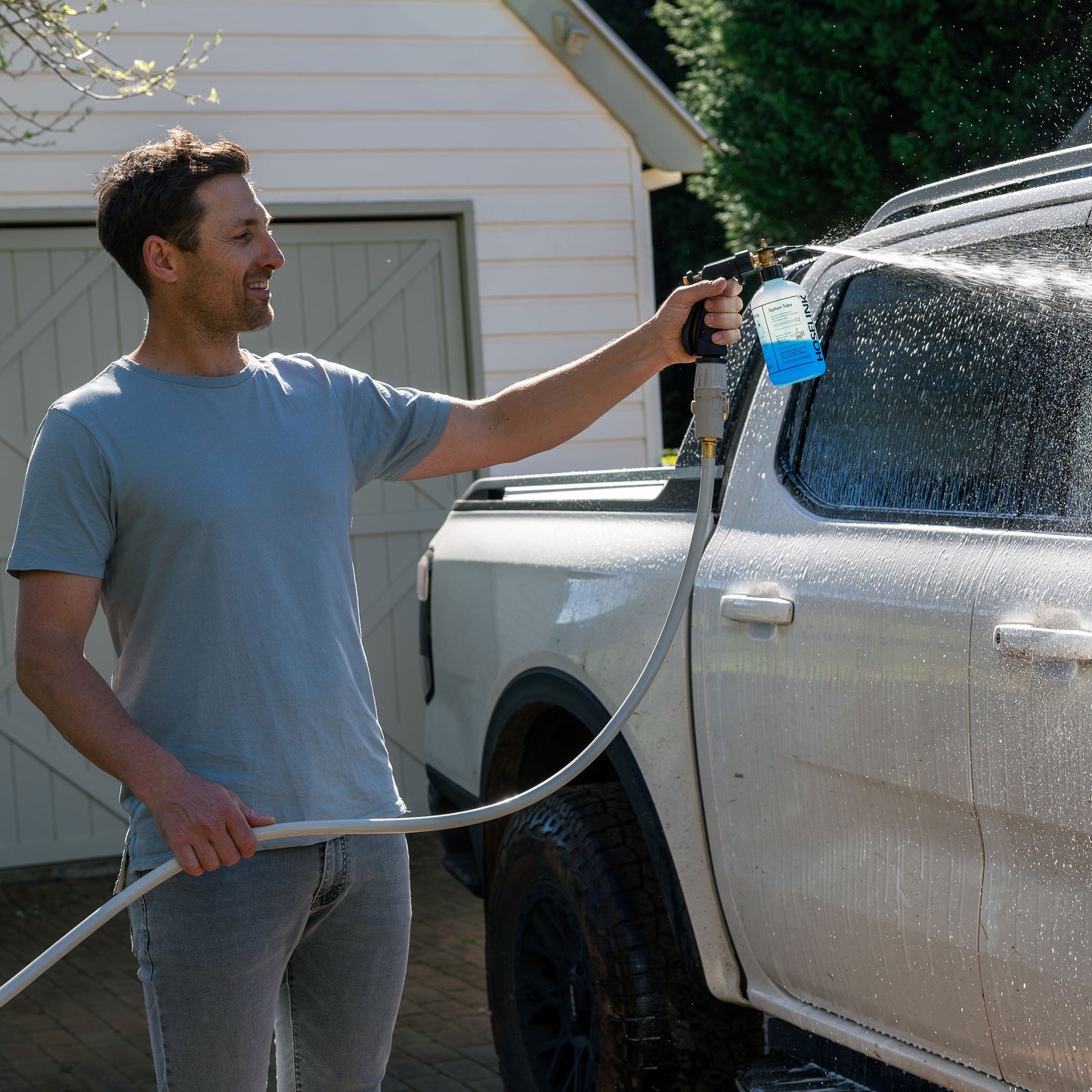 Ben Hayman using fertilizer sprayer with soap on car